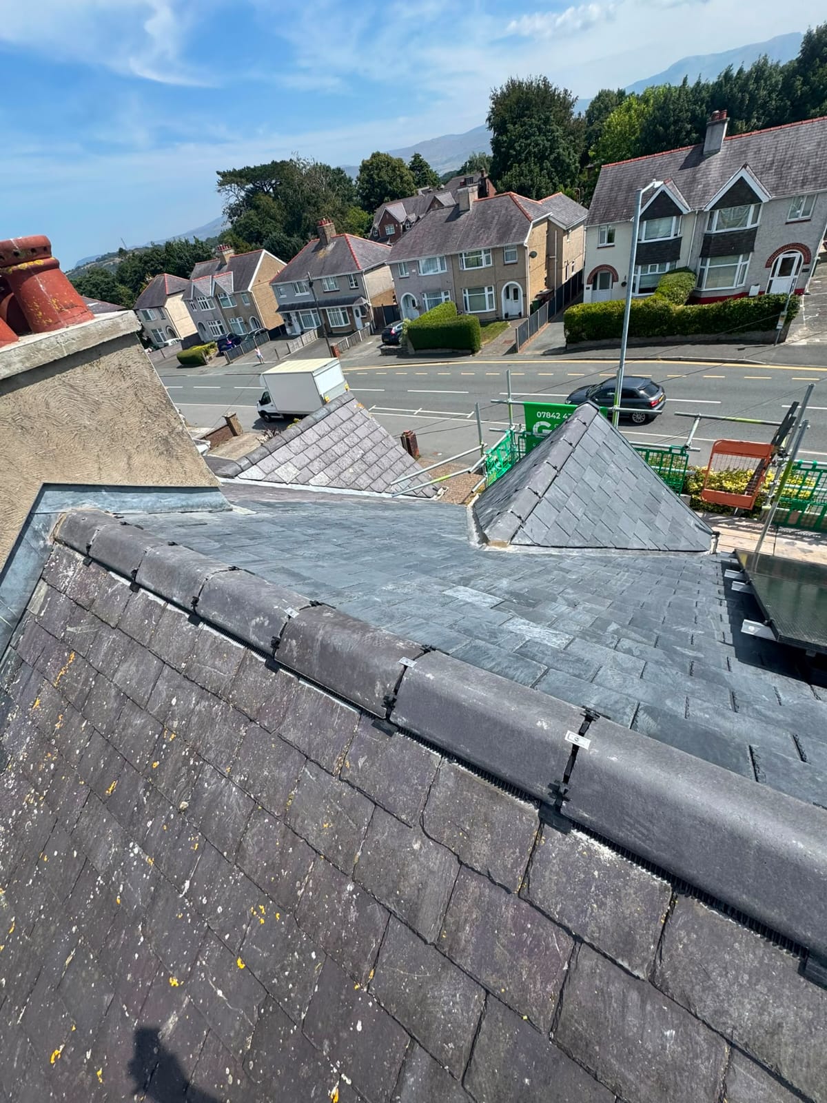 Completed natural slate roof with neat ridge tiles and lead detailing