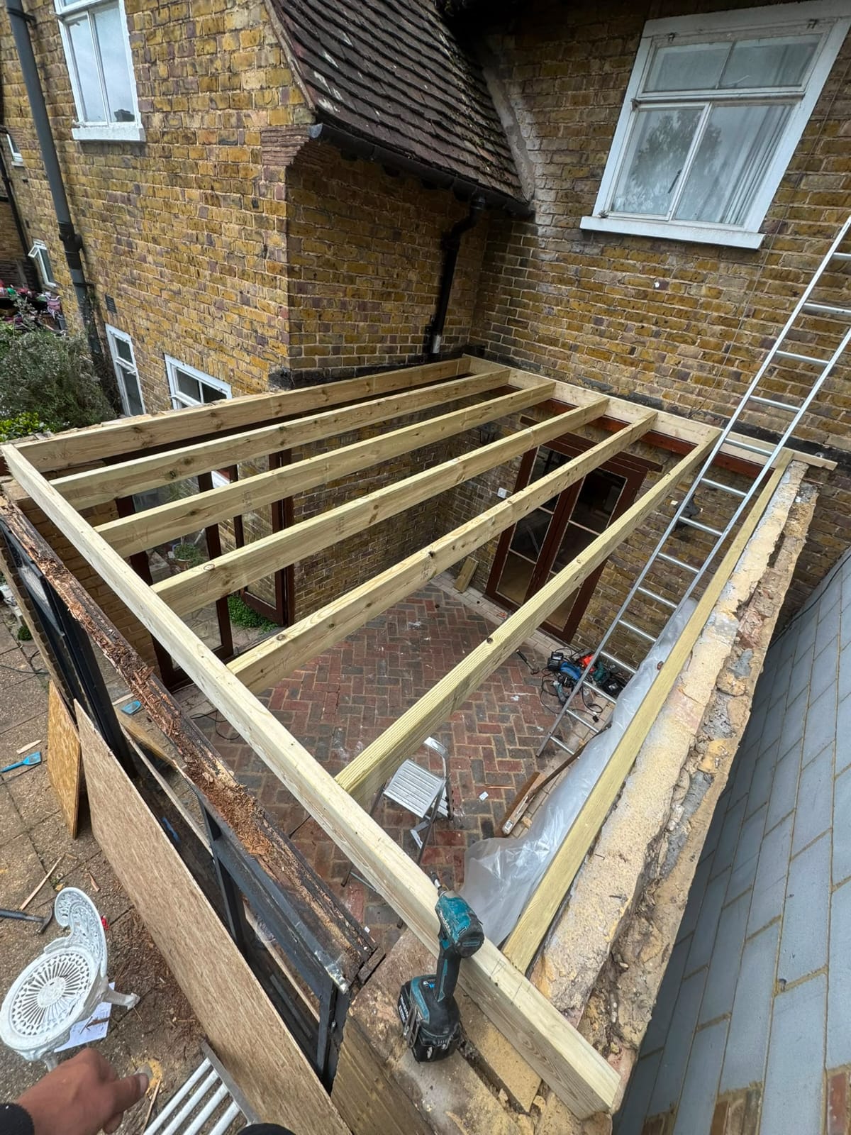 Flat roof replacement in progress with new membrane being laid