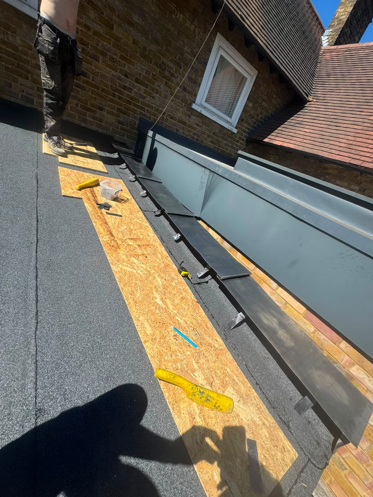 Flat roof replacement in progress with new membrane being laid