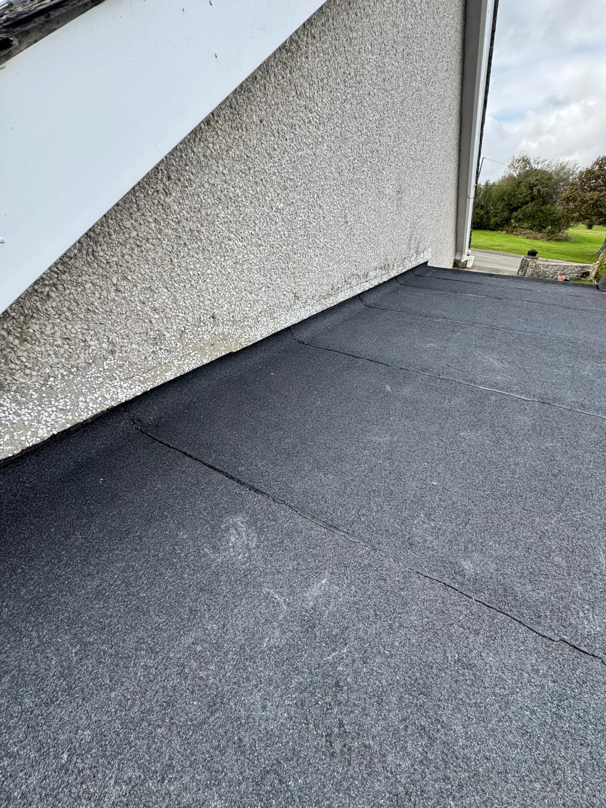 Completed flat roof replacement with clean seams and new edge trims